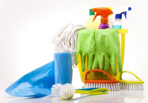 Step-by-step oven cleaning supplies and tools on a kitchen counter