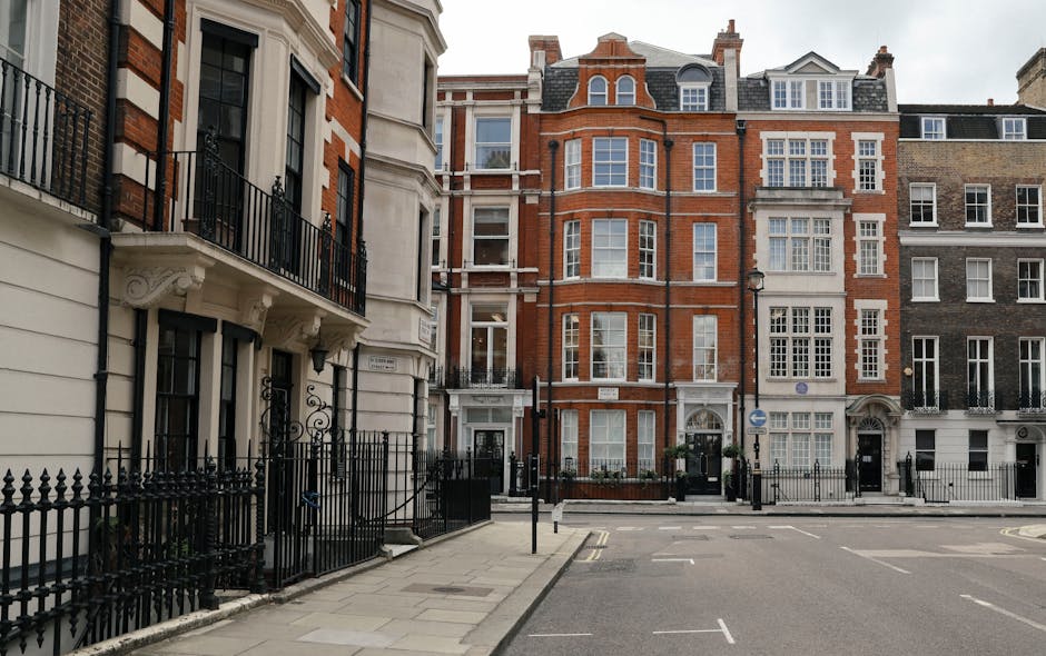 The image depicts the exterior front of a Hermes boutique housed within a historic stone building on W1 flats in Mayfair. The storefront features large glass windows showcasing an interior with warm l